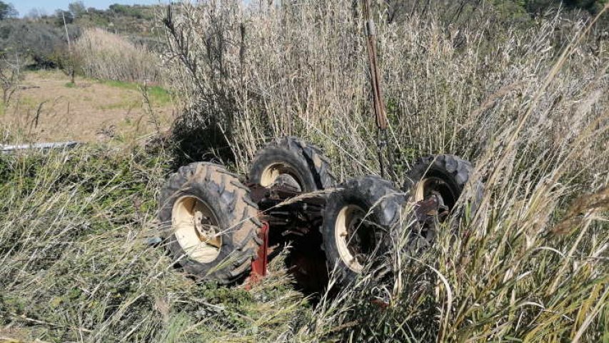 Il trattore capovolto imbragato da un cavo collegato ad una gru